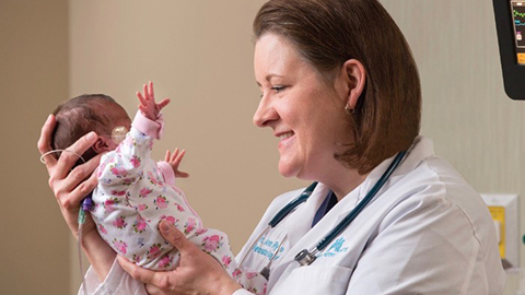 Médico sosteniendo un bebé